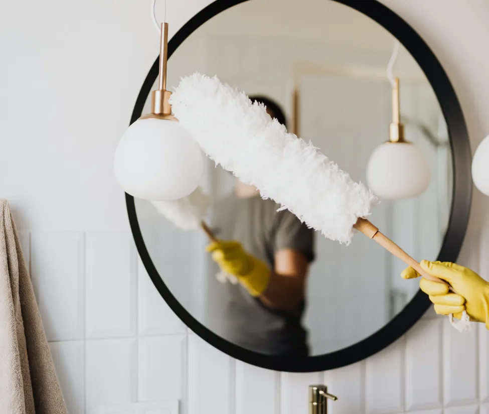 A lady's hand cleaning a mirror