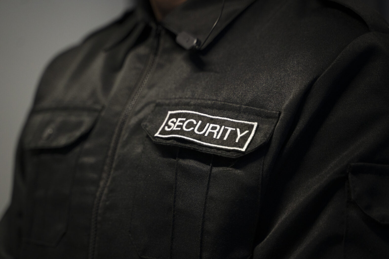 A security guard zoomed in till we only see his worksuit
